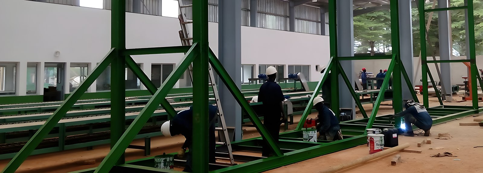Équipe SEM montant une charpente métallique en usine